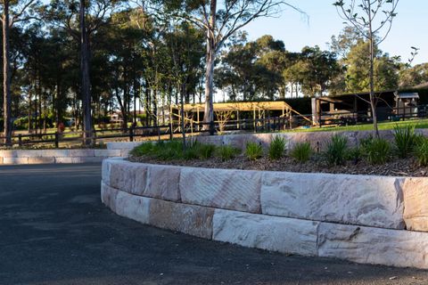 Finished two-tier sandstone block retaining wall beside the new gravel car park, Kenthurst NSW