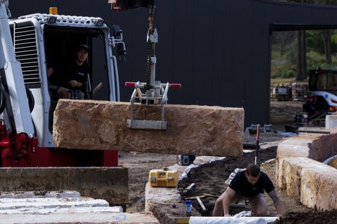 Crew placing a 2 m A-grade sandstone block with the Takeuchi block grab, Kenthurst NSW